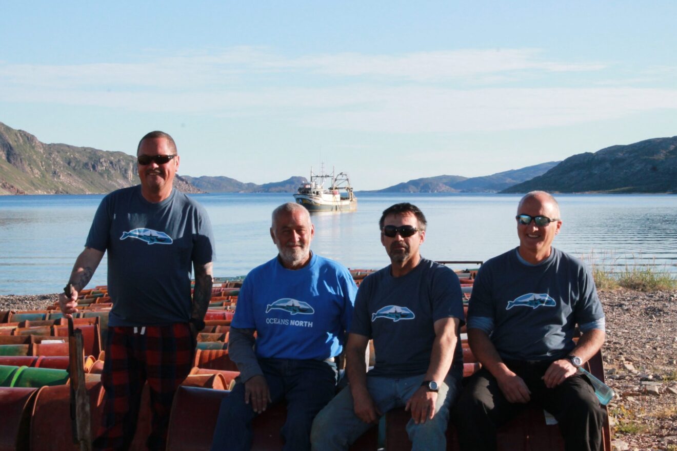 Members of the Oceans North team preparing to load the used oil drums onto a boat for disposal in Goose Bay.